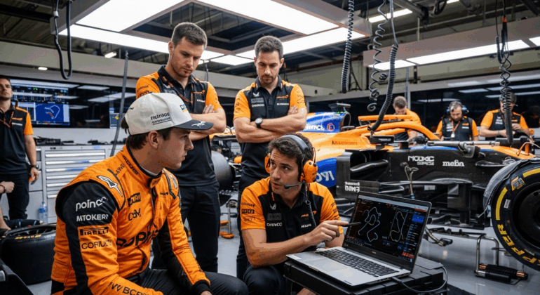 Lando Norris, McLaren's promising driver, sits in his team's pit, a thoughtful and analytical look on his face.